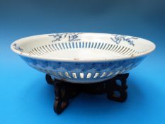 A reticulated 18thC Chinese blue and white pedestal dish with internal moulded prunus decoration on