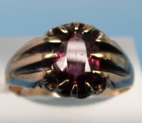 A yellow metal ring set with a garnet (size Q)