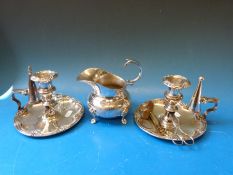 A pair of silver plated chamber sticks both with wick trimmers and snuffers together with a silver