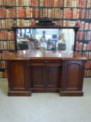 A Victorian walnut inverted breakfront mirror back sideboard with fitted drawers and shelves to the