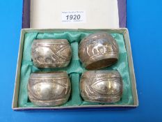 A set of four white metal napkin rings