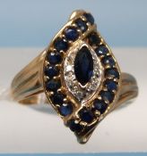 A 9ct gold ring set with a marquise cut sapphire surrounded by further sapphires in a twist setting