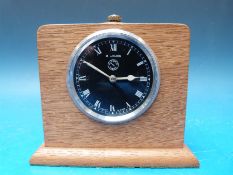 An eight day Jaeger dashboard clock with black dial and white spade hands,