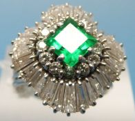A white metal ballerina ring set with a square emerald measuring approx 1.