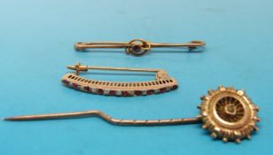 A gold brooch set with alternating diamonds and rubies,