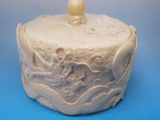 A Japanese ivory box finely carved with scrolling dragons amongst clouds,
