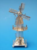 A Dutch white metal model of a windmill with figures to the base (11cm high)