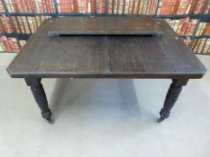 A mahogany dining table with additional leaf raised on turned legs and castors (W106 x Lmin142