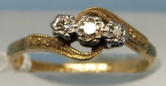 A yellow metal ring marked 18ct set with three diamonds (size N)
