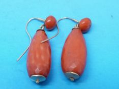 A pair of faceted tear drop coral earrings