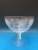 A pedestal glass punch bowl engraved to the body with grapes and vines raised on air twist stem