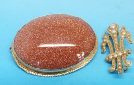 A 9ct gold brooch set with a large sun stone together with a yellow metal brooch in the form of a