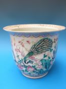A 19thC Chinese jardiniere with decoration of fighting peacocks amongst blossom
