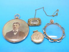 A 9ct gold framed example, a yellow metal framed glass locket,