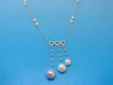 A white metal necklace marked 750, the three central circles set with diamonds,