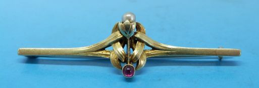 A yellow metal brooch set with a ruby and a pearl