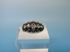A gold ring set with five graduating rose cut diamonds, the largest of approximately 0.