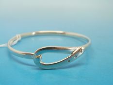 A silver bangle set with three diamonds by Ylang Ylang.