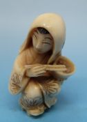 A Japanese ivory netsuke in the form of a geisha eating