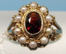 A 9ct gold ring set with a gamet surrounded by pearls (size J)