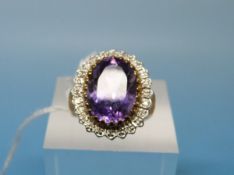 A 9ct gold ring set with a large amethyst surrounded by diamonds (size K)