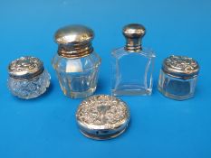 Four hallmarked silver topped dressing table bottles together with a further hallmarked silver top
