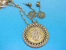 A yellow metal pendant marked 14ct decorated with a Chinese character with a matching pair of