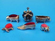 Five silver pin cushions including crown, shoe, tortoise and two pigs together with one other.