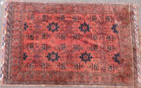 An orange ground rug with navy blue star shaped guls (L206 x W131cm)