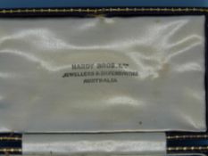 A gold stick pin set with turquoise in the shape of a horseshoe with a seed pearl to the centre (in