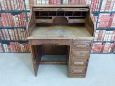 An oak roll top desk of small proportions, the desk fitted drawers and pigeon holes,