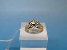 An 18ct gold ring set with diamonds in a flower cluster with textured shoulders (size N)