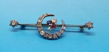 A Victorian yellow metal brooch set with diamonds in a crescent shape and with a sapphire,
