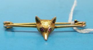 A yellow metal bar brooch with fox's head set with ruby eyes