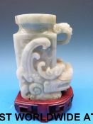 A Chinese jadeite archaistic vase in the form of a dragon, on pierced wooden stand (10.