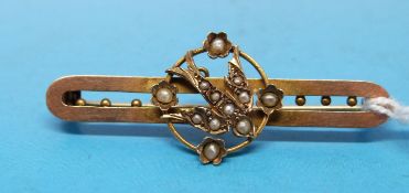 A yellow metal and seed pearl brooch decorated with a bird,
