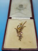 A 9ct gold brooch in the form of a bouquet of ferns tied with a bow set with five pearls,