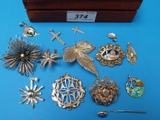 A collection of silver/ white metal brooches to include filigree examples, an enamel pendant,