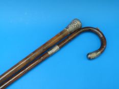 A white metal topped walking cane together with a hallmarked silver mounted walking stick