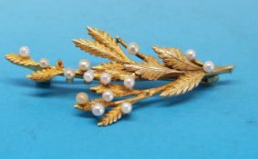 A gold brooch in a foliate design set with seed pearls