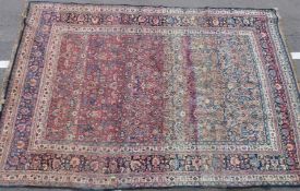 A large vintage woollen rug with multiple borders and red and blue ground (L373 x W251cm)