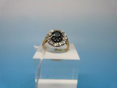 An 18ct gold ring set with a central sapphire surrounded by diamonds in a flower cluster (size L)