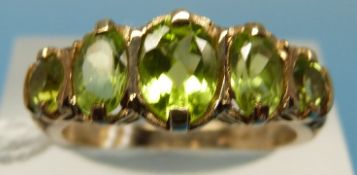 A 9ct gold ring set with five oval peridots (size O)