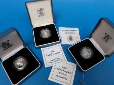 Three cased £1 silver coins with certificates 1998, 1989, and 1990 Royal arms,