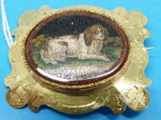 A Victorian micro mosaic brooch depicting a spaniel in ornate yellow metal surround