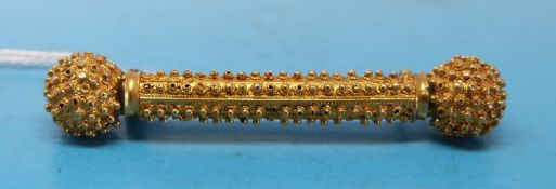 A yellow metal brooch with textured finish