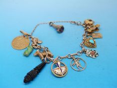 A 9ct gold charm bracelet with eleven charms to include a gold half sovereign, dog, squirrel,