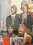 A framed Beatles poster c1967 showing the group holding the Sergeant Pepper LP together with some