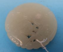 A finely carved Chinese white jade pendant in the form of a mythical beast (diameter 4.