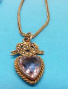 An Edwardian pendant marked 9ct gold set with a heart shaped amethyst surrounded by a bow set with